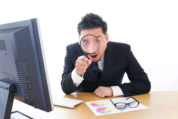 Young Businessman Looking Computer Magnifying Glass While Sitting Table Stock Image
