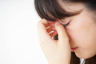 Baş ağrısı olan genç bir kadın, beyaz arka planda izole edilmiş.