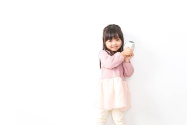 Küçük kız çalar saati tutuyor.