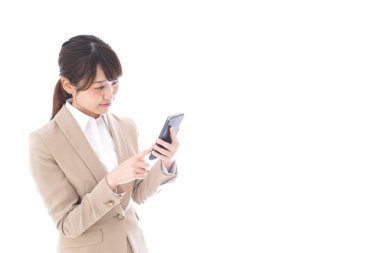 Beyaz arka planda izole edilmiş cep telefonu kullanan Asyalı iş kadını