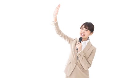 Beyaz arka planda mikrofonu olan genç bir iş kadını.