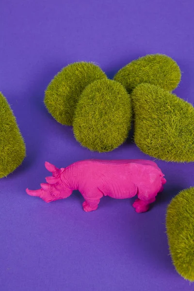 Rinoceronte Rosa Fuschia Tra Rocce Muschiate Incastonate Uno Sfondo Viola — Foto Stock