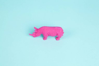 Pembe bir Fuschia gergedanı, turkuaz pastel arka plan üzerine kurulmuş. Atmosfer. En düşük renk hala yaşam fotoğrafçılığı 