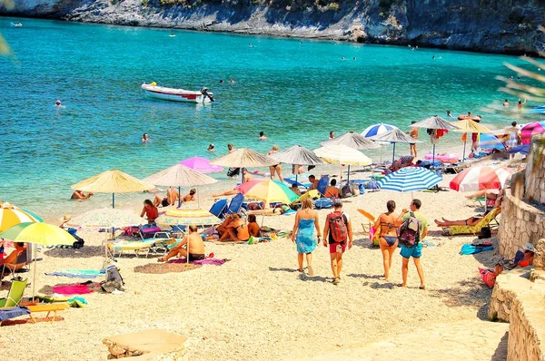 View of the beach on a sunny day by the sea with sun beds and colorful umbrellas — Stock Photo, Image