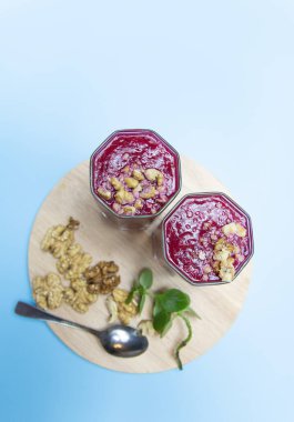 Mavi arka planda fındık dilimli kızılcık püresi..