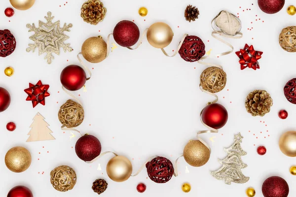 Yeni yıl ve Noel aralığı. Kırmızı ve altın Noel süslemeleri - parlak toplar, yıldızlar, çam kozalakları ve beyaz kağıt arka planda dekoratif kurdele. Üst görünüm, düz görünüm, kopyalama alanı
