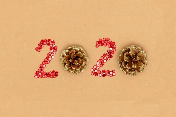 2020 hecho de destellos y conos de pino decorativos en hoja de papel artesanal. Feliz año nuevo 2020 concepto — Foto de Stock