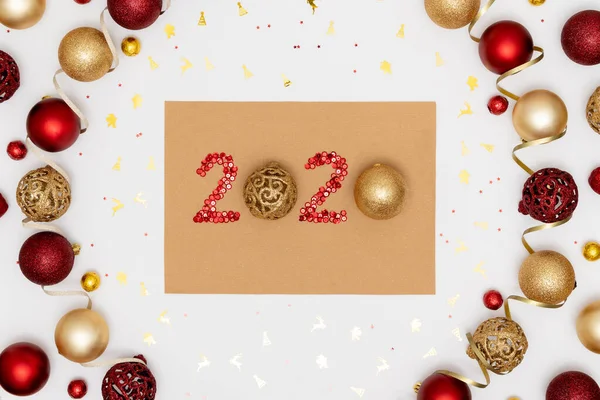 2020 hecho de bálsamos rojos y decorativos de navidad dorada en hoja de papel artesanal. Marco de bolas de Navidad. Feliz año nuevo 2020 concepto — Foto de Stock