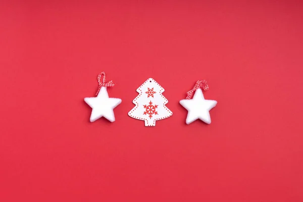 Πρωτοχρονιά και Χριστουγεννιάτικη σύνθεση από λευκά αστέρια, χριστουγεννιάτικο δέντρο σε κόκκινο φόντο. Πάνω άποψη, επίπεδη lay, αντίγραφο χώρου — Φωτογραφία Αρχείου