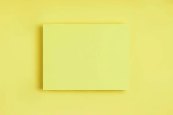 Ελάχιστη γεωμετρική σύνθεση πλαισίου mock up. Λευκά φύλλα χαρτιού καρτ ποστάλ σε λεπτό κίτρινο φόντο. Πρότυπο σχεδιαστική κάρτα πρόσκληση. Πάνω άποψη, επίπεδη lay, αντίγραφο χώρου. Οριζόντια κατεύθυνση. — Φωτογραφία Αρχείου