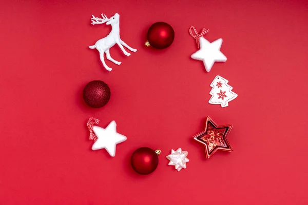 Yeni yıl ve Noel kompozisyonu. Kırmızı arka planda çelenk. Üst görünüm, düz görünüm, kopyalama alanı