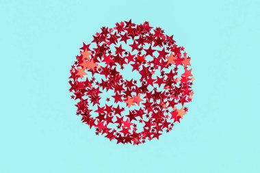 Kırmızı yıldızlar, pastel mavisi arka planda şekillenmiş konfetileri parlıyor. Şenlikli arkaplan.