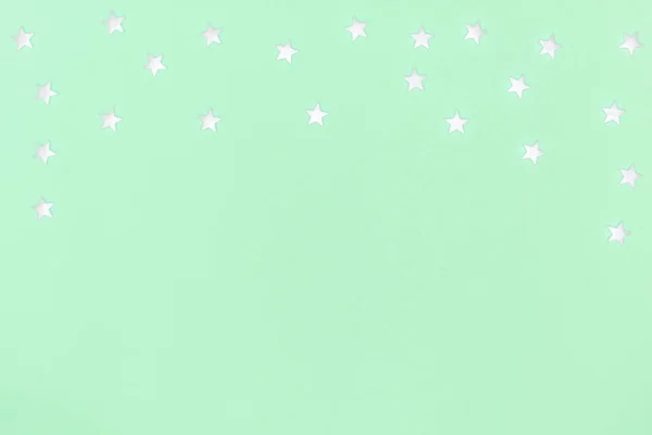 New year, Christmas frame, greeting card. White stars on pastel green background. Top view, flat lay, copy space — 图库照片