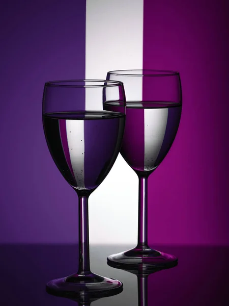 Due bicchieri di vino silhouette piena su sfondo colorato. Bevanda alcolica . — Foto Stock