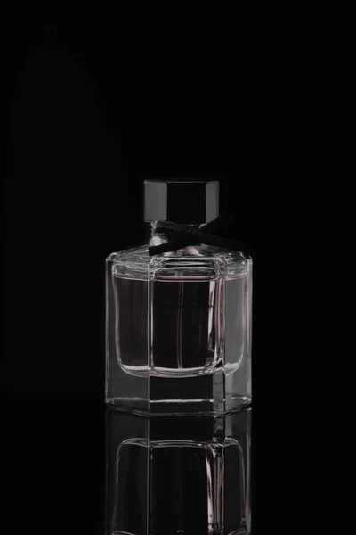 Italy, Milan - 15 November 2019: Perfume glass bottle of Flora Gorgeous Gardenia by Gucci on black background on a mirror surface with reflection on table. Studio photography — Stock Photo, Image