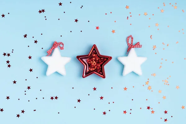 Composición de Año Nuevo y Navidad de estrellas blancas y destellos sobre fondo azul pastel. Vista superior, plano, espacio para copiar — Foto de Stock