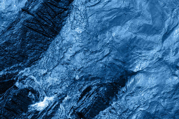 Texture of blue sea water surface background. Trendy color of the year 2020.