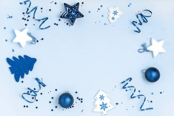 Año Nuevo y composición navideña. Marco de bolas, estrella, árbol de Navidad sobre fondo azul. Vista superior, plano, espacio de copia. Color de moda del año 2020 . —  Fotos de Stock