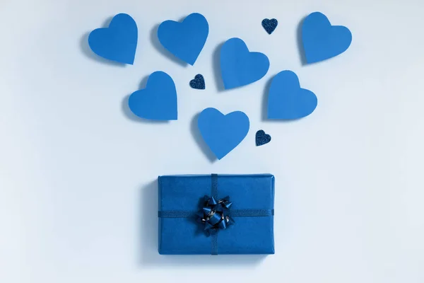 Сочинение ко Дню Святого Валентина. Голубые сердца вылетают из подарочной коробки. Любовное послание представляет собой концепцию. Плоский, вид сверху, сверху Стоковое Фото