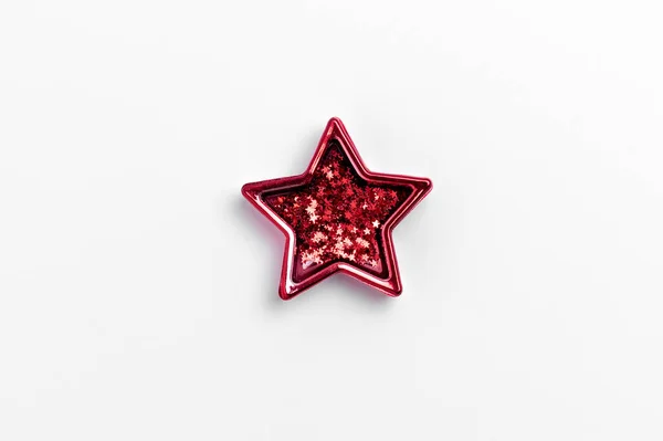 Christmas five pointed red star on white background. Christmas glittery decoration.