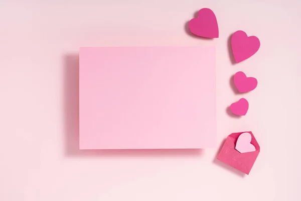 Sevgililer Günü kompozisyonu. Mor pembe kalpler. Pastel pembe arka planda boş kağıtlar. Üst görünüm, düz görünüm, kopyalama alanı