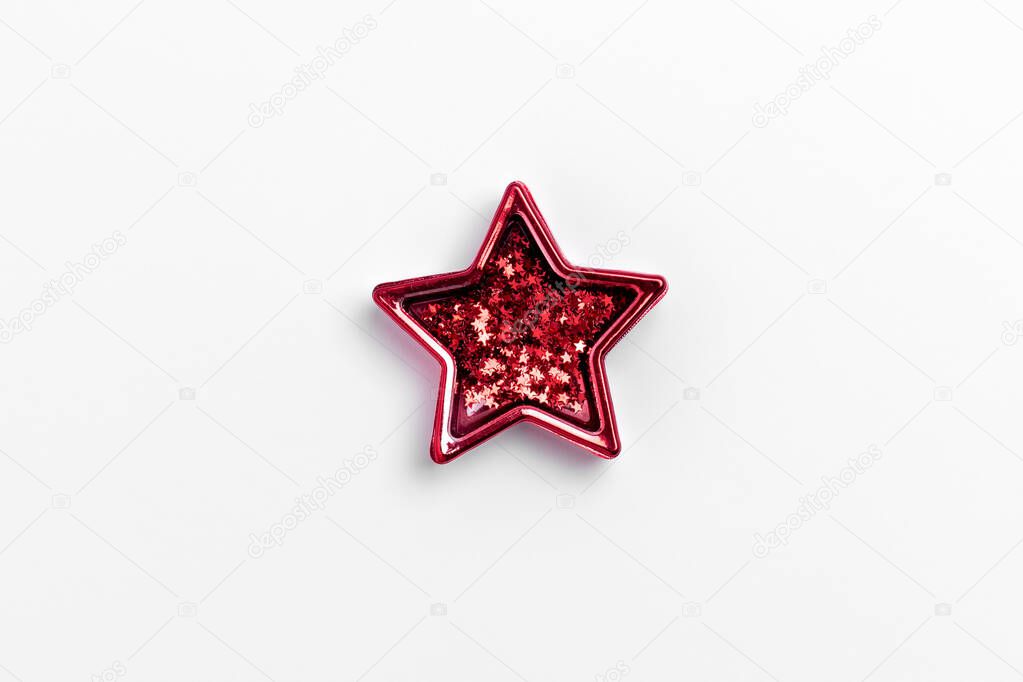 Christmas five pointed red star on white background. Christmas glittery decoration.