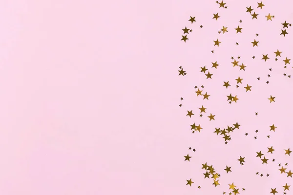 ピンクの背景に金色の星の輝きのコンフェッティからのフレーム。祭りの背景. — ストック写真