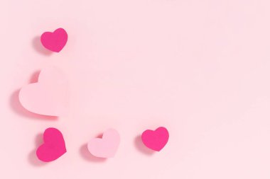 Sevgililer Günü kompozisyonu. Pastel pembe arka planda mor kalpler. Üst görünüm, düz görünüm, kopyalama alanı
