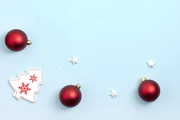 Πρωτοχρονιά και Χριστουγεννιάτικη σύνθεση. Πλαίσιο από κόκκινο και άσπρο χριστουγεννιάτικα παιχνίδια σε μπλε φόντο. Πάνω άποψη, επίπεδη lay, αντίγραφο χώρου — Φωτογραφία Αρχείου