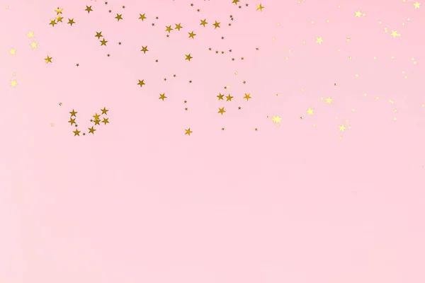 Golden stars glitter confetti on pink background. Festive backdrop. — ストック写真