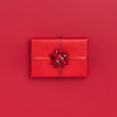 Yeni yıl ve Noel kompozisyonu. Kırmızı arka planda hediye kutusu. Üst görünüm, düz görünüm, kopyalama alanı