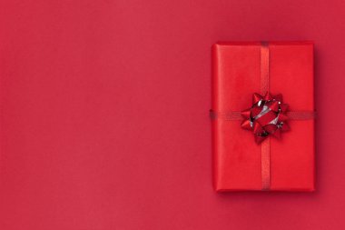 Yeni yıl ve Noel kompozisyonu. Kırmızı arka planda hediye kutusu. Üst görünüm, düz görünüm, kopyalama alanı