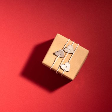 Yeni yıl ve Noel kompozisyonu. Kırmızı arka planda hediye kutusu. Üst görünüm, düz görünüm, kopyalama alanı