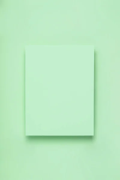 Minimal frame geometric composition mock up. Blank sheet of green paper on green background. Template design invitation card. Top view, flat lay, copy space. Horizontal orientation. — ストック写真