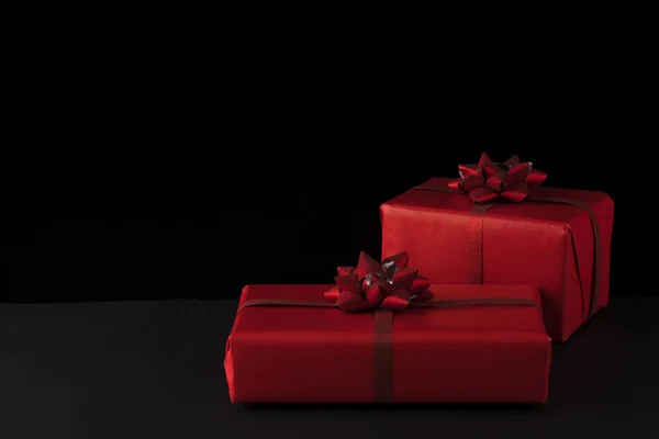 Sevgililer Günü konsepti. Kırmızı Noel hediye kutuları siyah arka planda. Tebrik kartı, kartpostal.