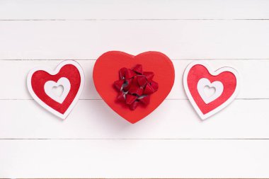 Sevgililer Günü kompozisyonu. Kalp, beyaz ahşap yüzeyde bir hediye. Sevgililer Günü konsepti. Düz yatıyordu, üstten, yukarıdan.