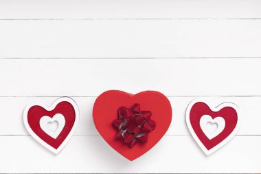 Sevgililer Günü kompozisyonu. Kalp, beyaz ahşap yüzeyde bir hediye. Sevgililer Günü konsepti. Düz yatıyordu, üstten, yukarıdan.