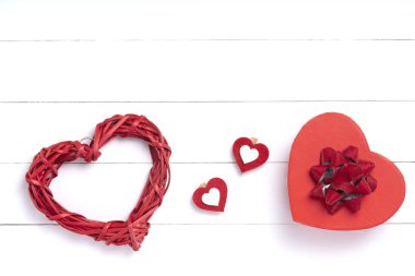 Sevgililer Günü kompozisyonu. Kalp, beyaz ahşap yüzeyde bir hediye. Sevgililer Günü konsepti. Düz yatıyordu, üstten, yukarıdan.