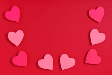 Kırmızı yüzeyde sevgililer günü kalpleri. Üst görünüm, düz görünüm, yukarıdan, boşluğu kopyala