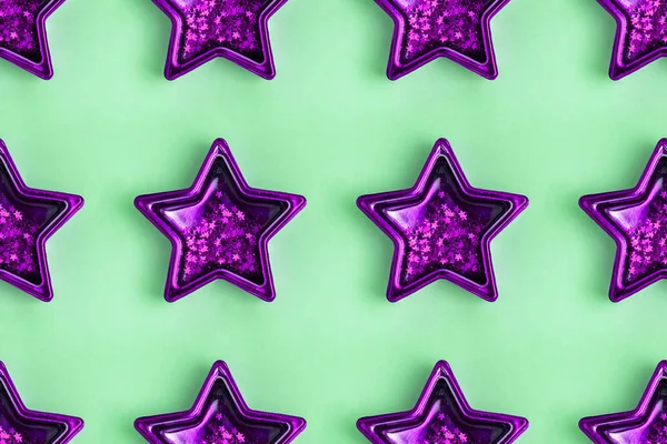 Бесшовный рисунок с пятью заостренными фиолетовыми металлическими звездами на пастельно-зеленой поверхности . — стоковое фото