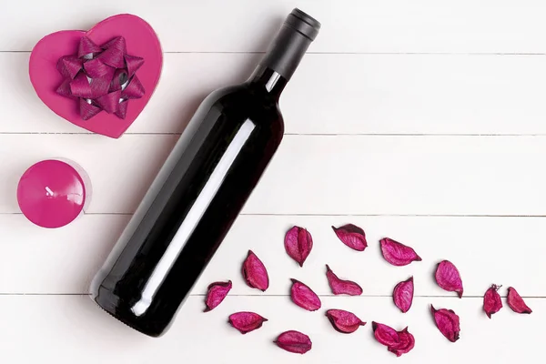 Corazón, vela, botella de vino en la superficie de madera blanca . —  Fotos de Stock