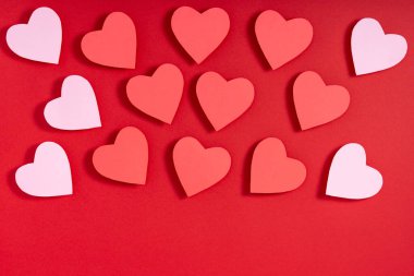 Kırmızı yüzeyde sevgililer günü kalpleri. Üst görünüm, düz görünüm, yukarıdan, boşluğu kopyala