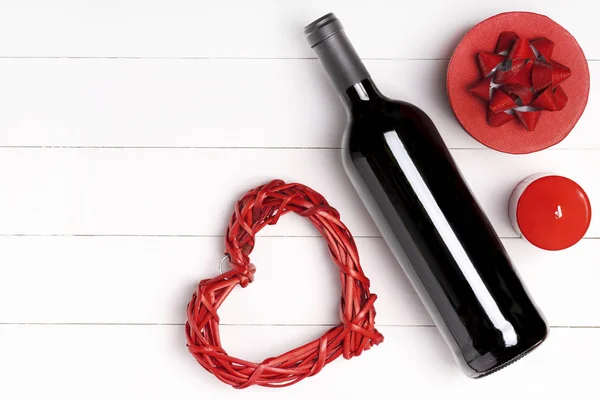 Corazón, vela, botella de vino en la superficie de madera blanca . —  Fotos de Stock