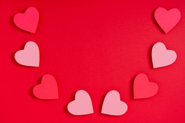Kırmızı yüzeyde sevgililer günü kalpleri. Üst görünüm, düz görünüm, yukarıdan, boşluğu kopyala