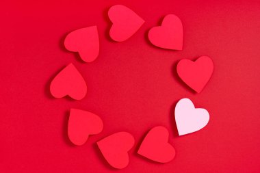 Kırmızı yüzeyde sevgililer günü kalpleri. Üst görünüm, düz görünüm, yukarıdan, boşluğu kopyala