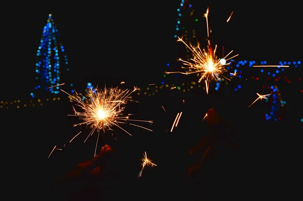 Männliche Hand hält eine brennende Wunderkerze,. für alle Feste wie — Stockfoto