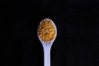 Siyah arka planda darı tohumları, beyaz kaşıkta değirmen taneleri, ba