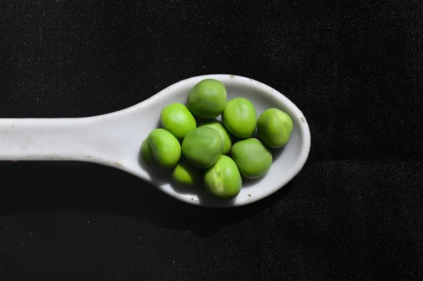 Cuchara en frijoles de guisantes, cuchara blanca en frijoles de guisantes, vista cercana de g —  Fotos de Stock