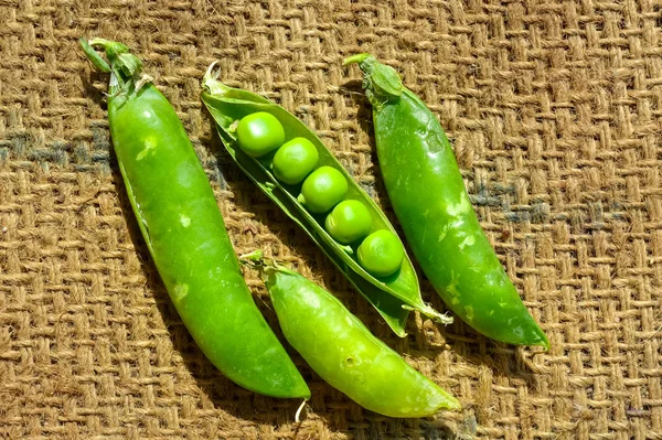 Erbsen auf landwirtschaftlichem Hintergrund, grüne Erbsen von oben, heilen — Stockfoto