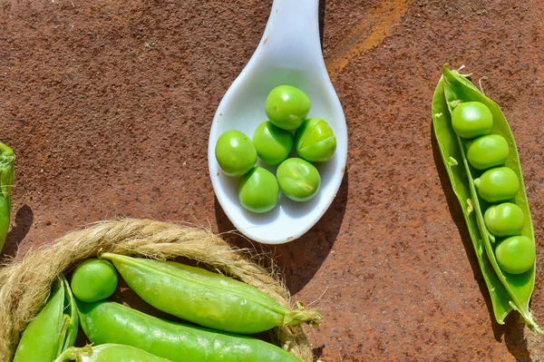 Piselli verdi e cucchiaino bianco, piselli verdi giovani in ciotola e Po — Foto Stock